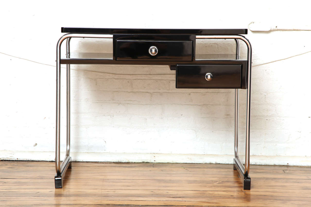 Modernist Desk, R C Qoquery for Thonet  Chrome tubular structure with black lacquered wood top and 2 drawers. 
Bibliographie : Metallmoble 1925-1940