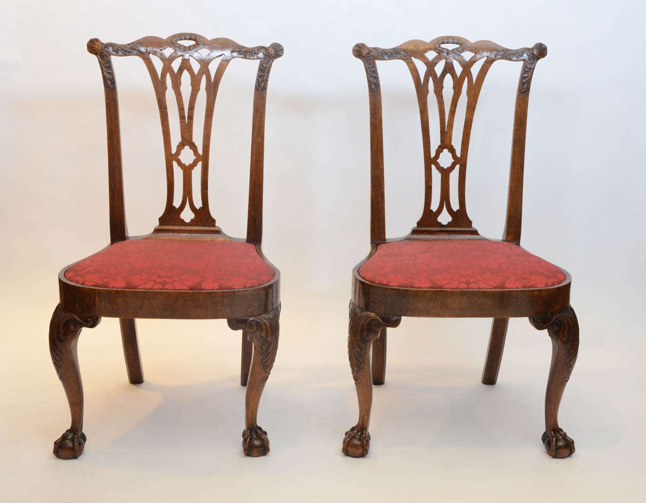 A fantastic pair of George II period walnut Side Chairs, the shaped carved splat backs over drop in seats on the cabriole legs with carved knees terminating in ball and claw feet to the front and chamfered splay legs to the back.