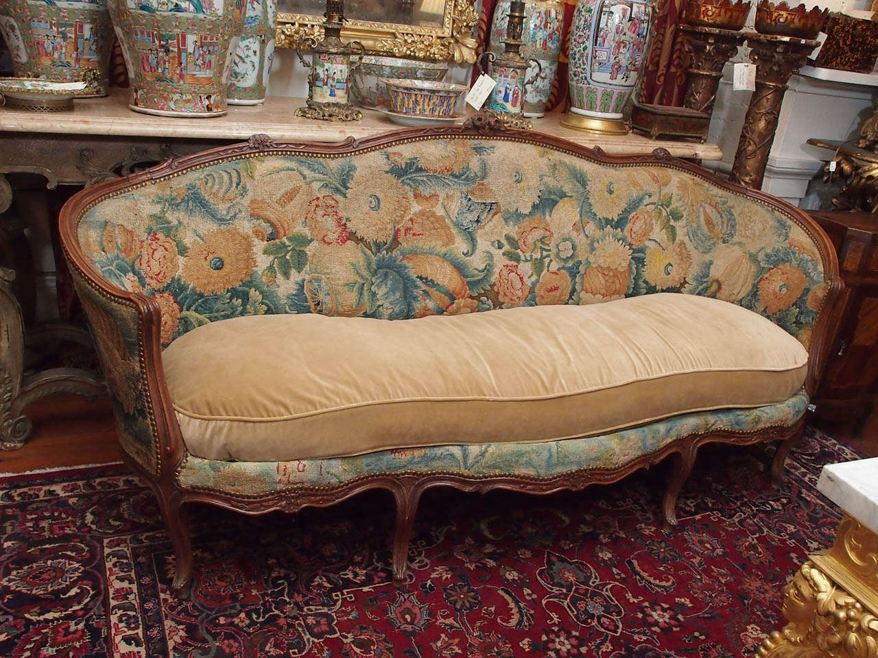 French Louis XV walnut canape with original needlepoint upholstery.  The back and later replacement velvet cushion.
The frame has some old repairs as seen in the photos.