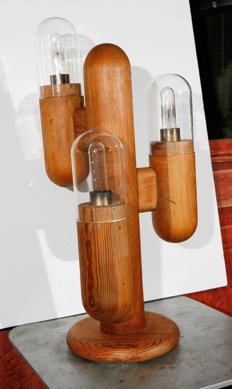 A wooden cactus form table lamp with glass globular shades.