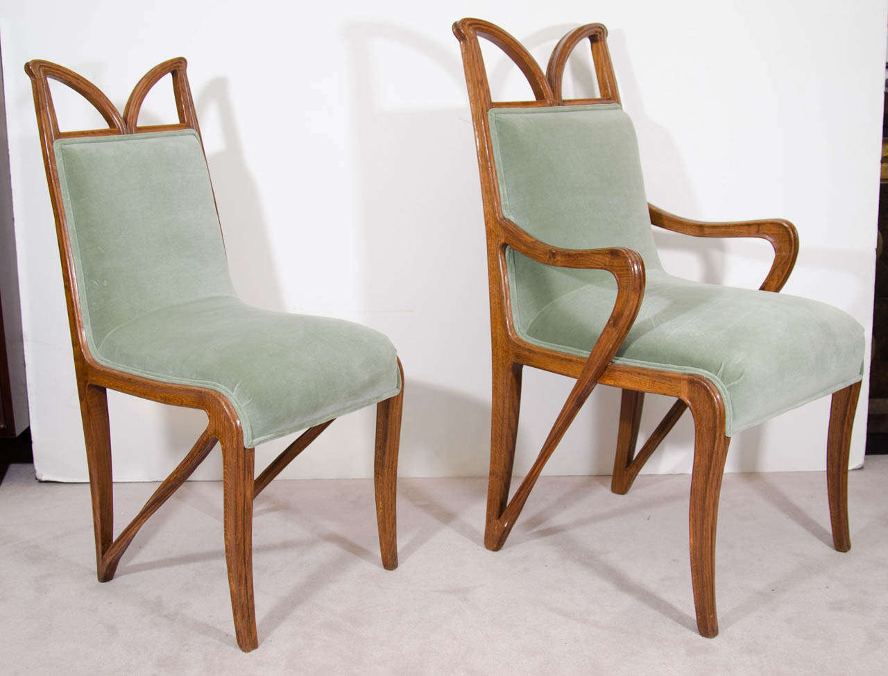 A French vintage set of four early 20th century chairs, including two armchairs and two side chairs, designed in the Art Nouveau mode, each upholstered in green velvet, against beautifully carved wood frames. 