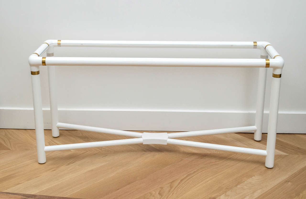 White lacquered console with brass accents.