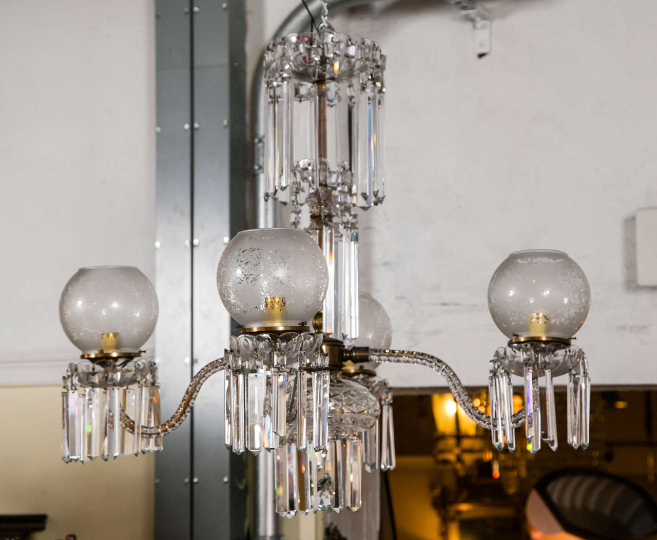 A Victorian crystal and globe four-arm chandelier. Long hanging crystal prisms and etched glass globes hi light this late 19th century Victorian chandelier. The central brass crystal covered support having four lighted arms each with large crystals