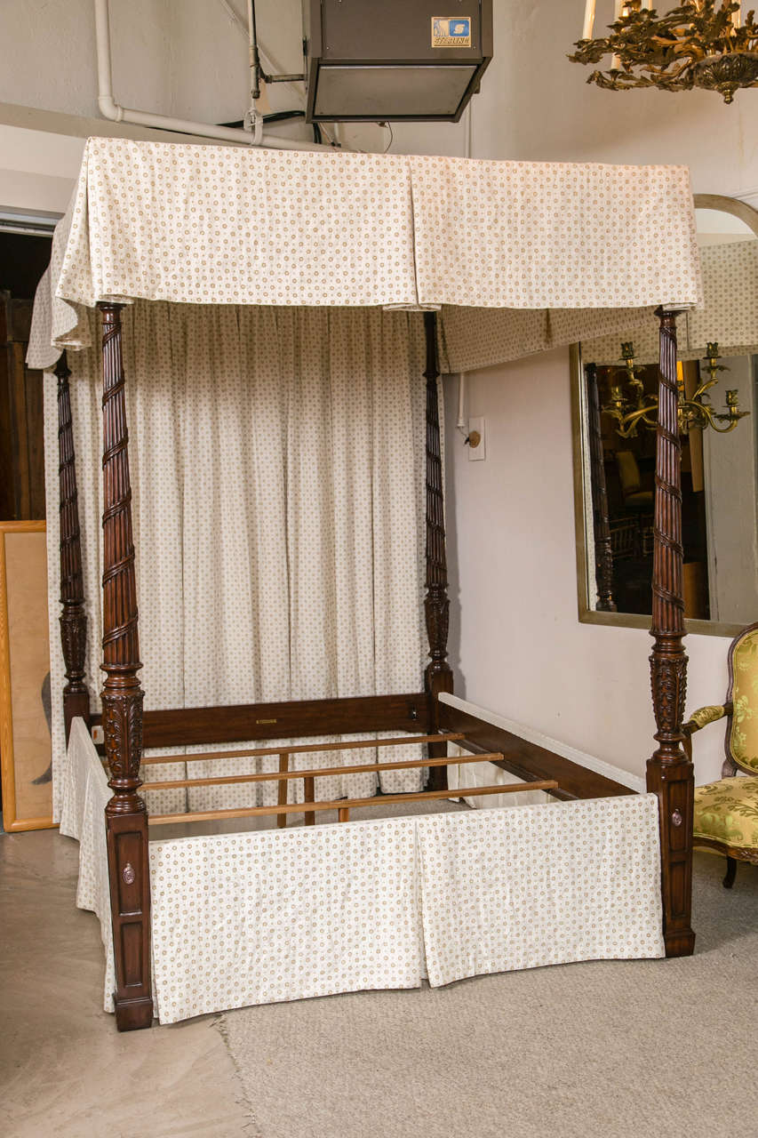 A carved Georgian style four-poster bed. This fine custom quality bed has custom drapes all around as well as four carved posters leading to a canopy top.