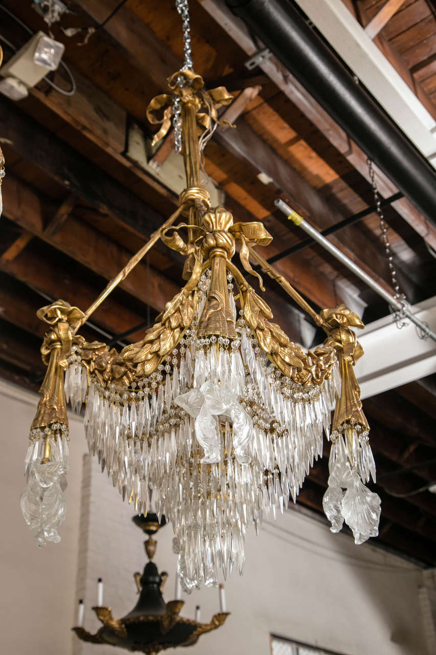 Pair of Bronze and Crystal Chandeliers Late 19th Century. Pair of very decorative bronze and drop crystal chandeliers. All around finely chased leaf and vine design bronze base supporting a group of hanging crystals.
