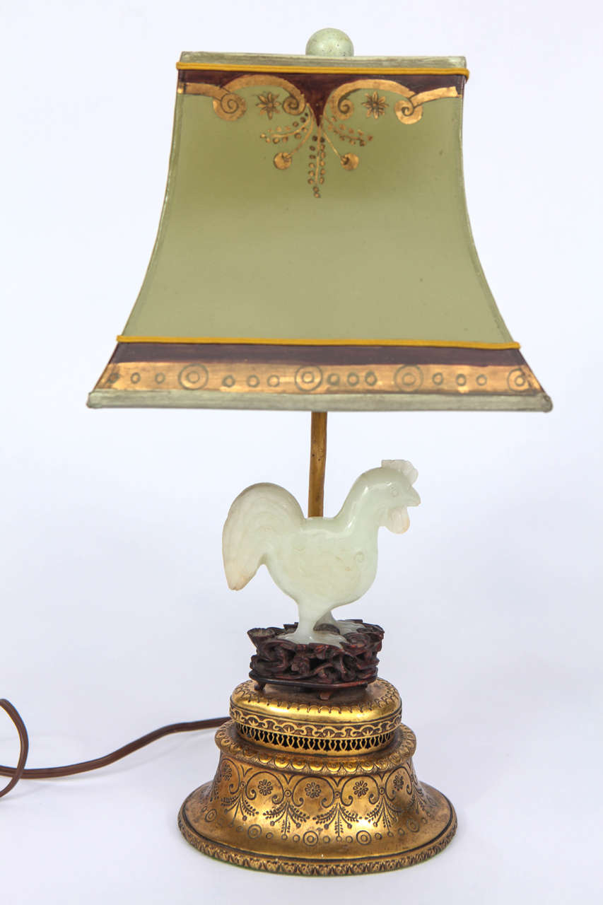 Single 19th century Chinese jade rooster lamp French mounted on doré bronze base. The shade is included and is handmade of parchment paper. It is hand gilded and decorated. The lamp has been newly wired. The base measurement is 5.5 inches x 4 inches.