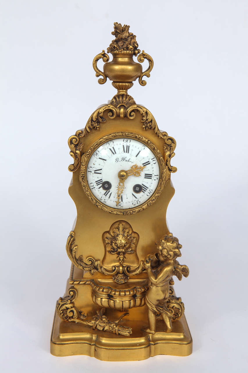 Pendule en bronze doré finement ciselé de la fin du XIXe siècle, avec motif de chérubin et de fontaine.