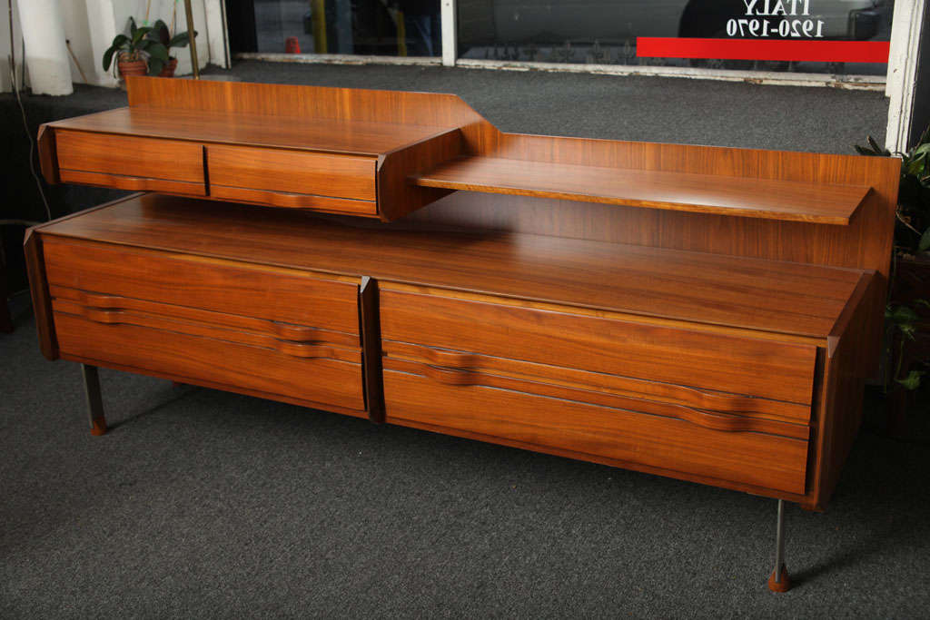Exciting walnut six-drawer credenza, made in 1955 in Milan by Rullo Proserpio. Wonderful strap wood handlers and steel legs with wood sabots. Unusual form.
 