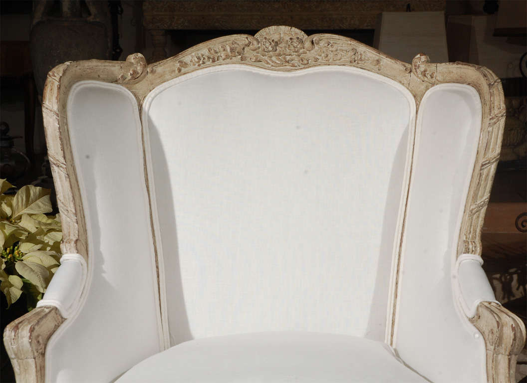old painted french arm chair upholstered in white belgian linen . 