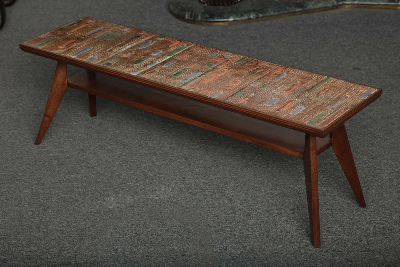 Exciting enamel top cocktail table made in 1950 in Milan.
Seven multicolor enamel panels with gold highlights set into a walnut base.
Wonderful design.
 