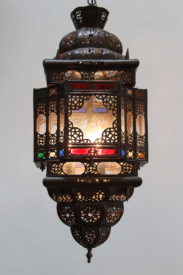 Moroccan light fixture, delicately handcrafted metal with filigree. Moorish details on handblown clear and colored glass in red, green and blue.
Wired with a cluster of three lights. 
Comes with chains and canopy, chains could be adjusted to your