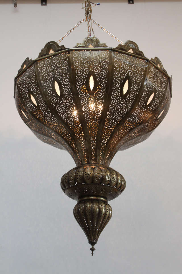 Oversize exquisite filigree pierced brass Moroccan chandelier in Alberto Pinto style.
This exquisite Moroccan light fixture is delicately handcrafted and chiseled with Fine filigree designs, adorned with milky glass.
Moorish bronze patina finish,