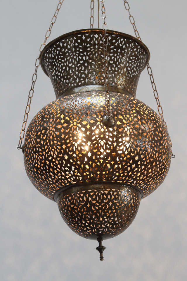 Large fabulous pierced Moroccan brass Moorish style chandelier.
Handcrafted brass Moroccan light pendant in the style of Alberto Pinto Moorish design.
This Moorish light fixture is delicately handcrafted in brass repousse and chiselled with fine