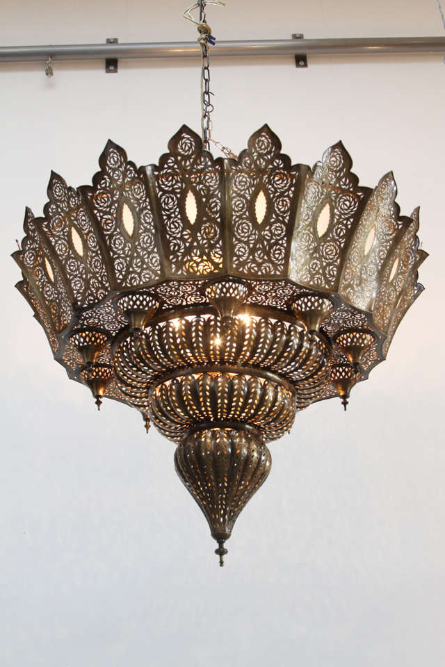 Oversize filigree pierced brass Moroccan chandelier in the style of Alberto Pinto.

Delicately hand crafted and chiseled with fine filigree designs and hand blown milky glass.

Rewired for electricity. Total height 43