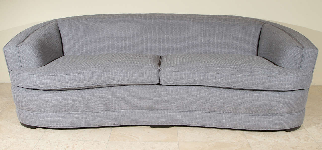 This 1940's Hollywood regency style sofa has been reupholstered in a blue / gray textured fabric. The sofa retains the original separate spring cushions.