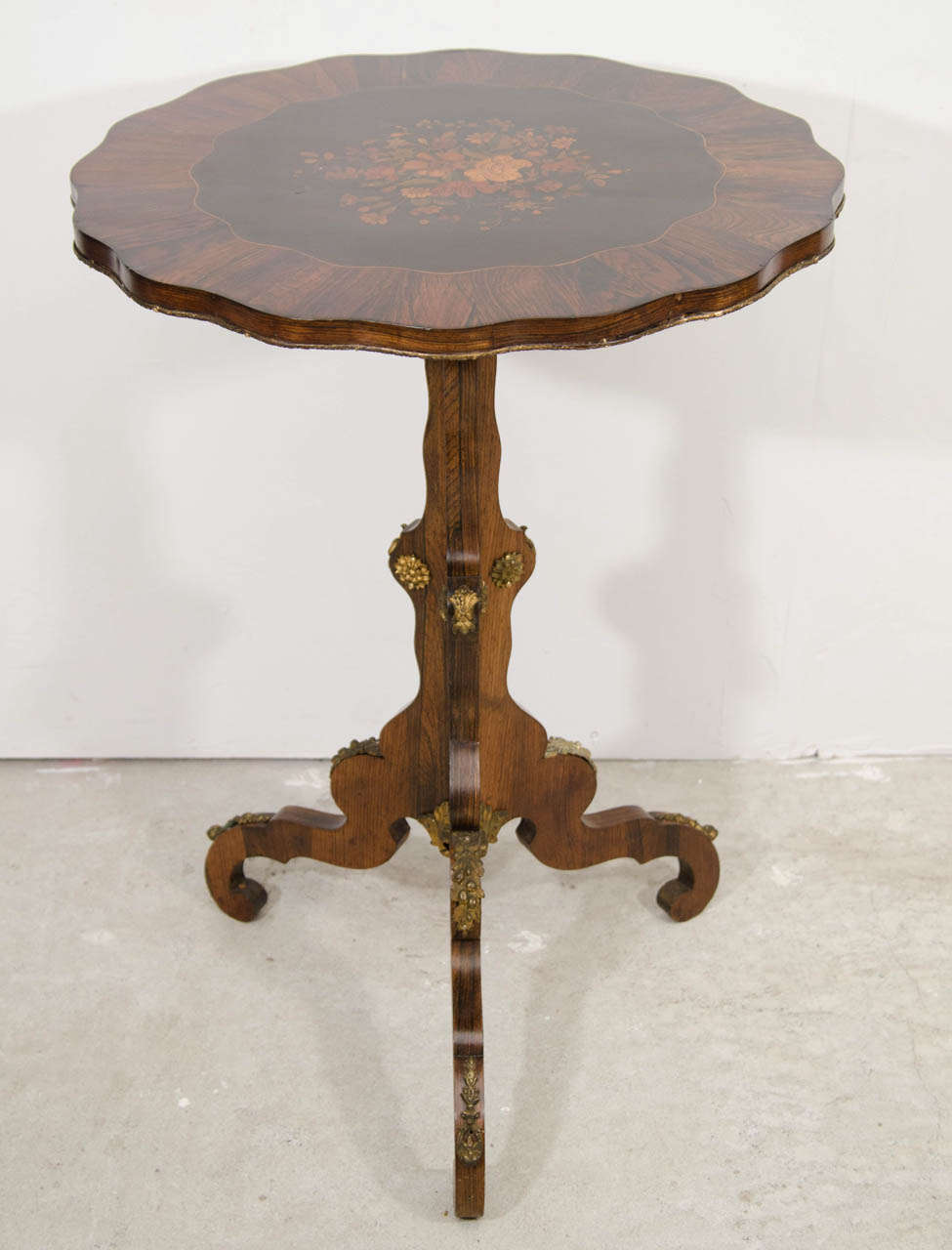 A British ,breakfast table, rosewood marquetry inlaid in the center of the table with  brass decorating the edge and the legs.