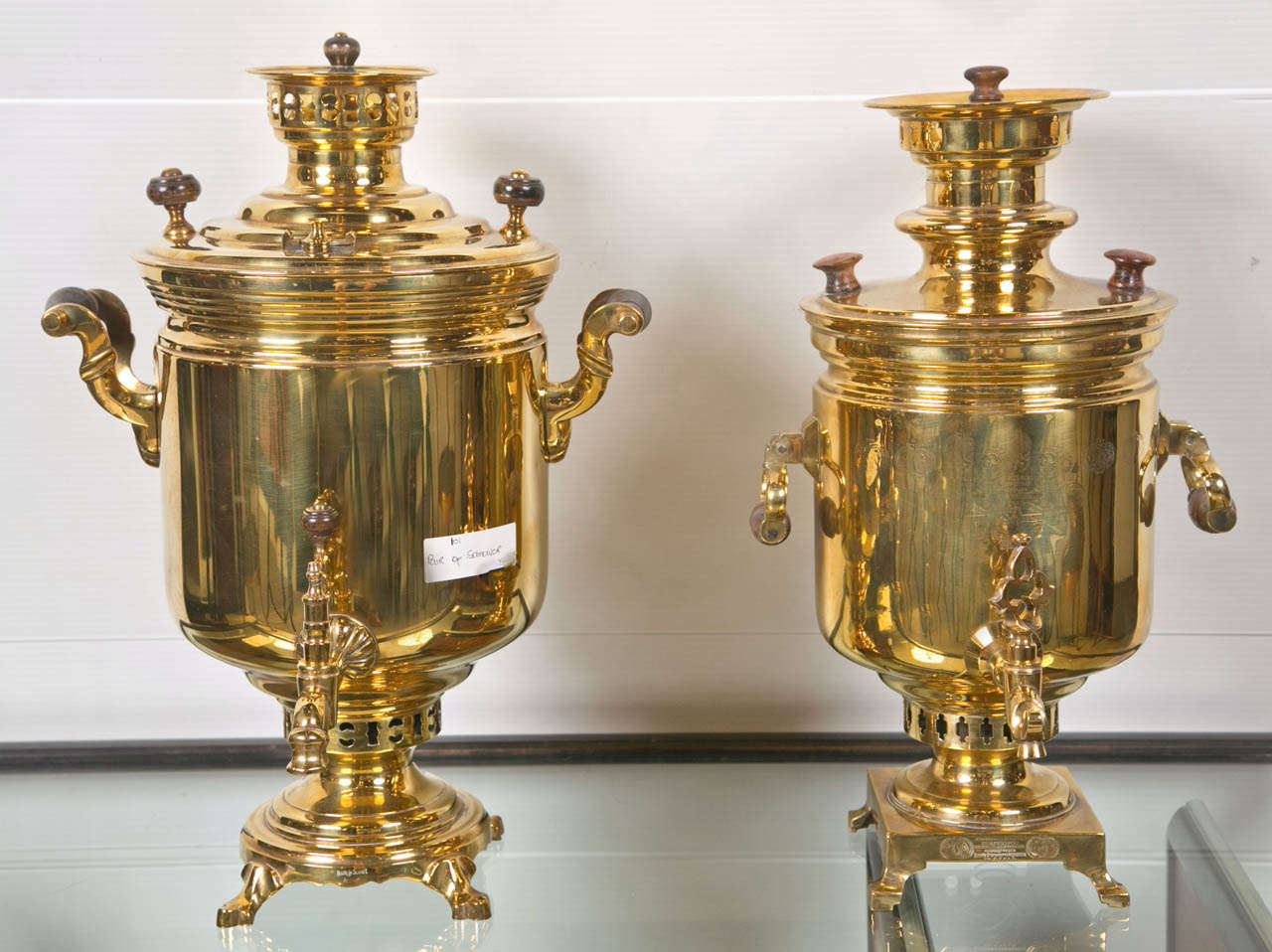 A fine compatible pair of brass Russian samovar's,  never used. Each having wooden handles and of a heavy brass structure.  Both signed, dated and hallmark stamped in Russian. Both stamped Made in Soviet Union.  This fine pair of quality samovar's