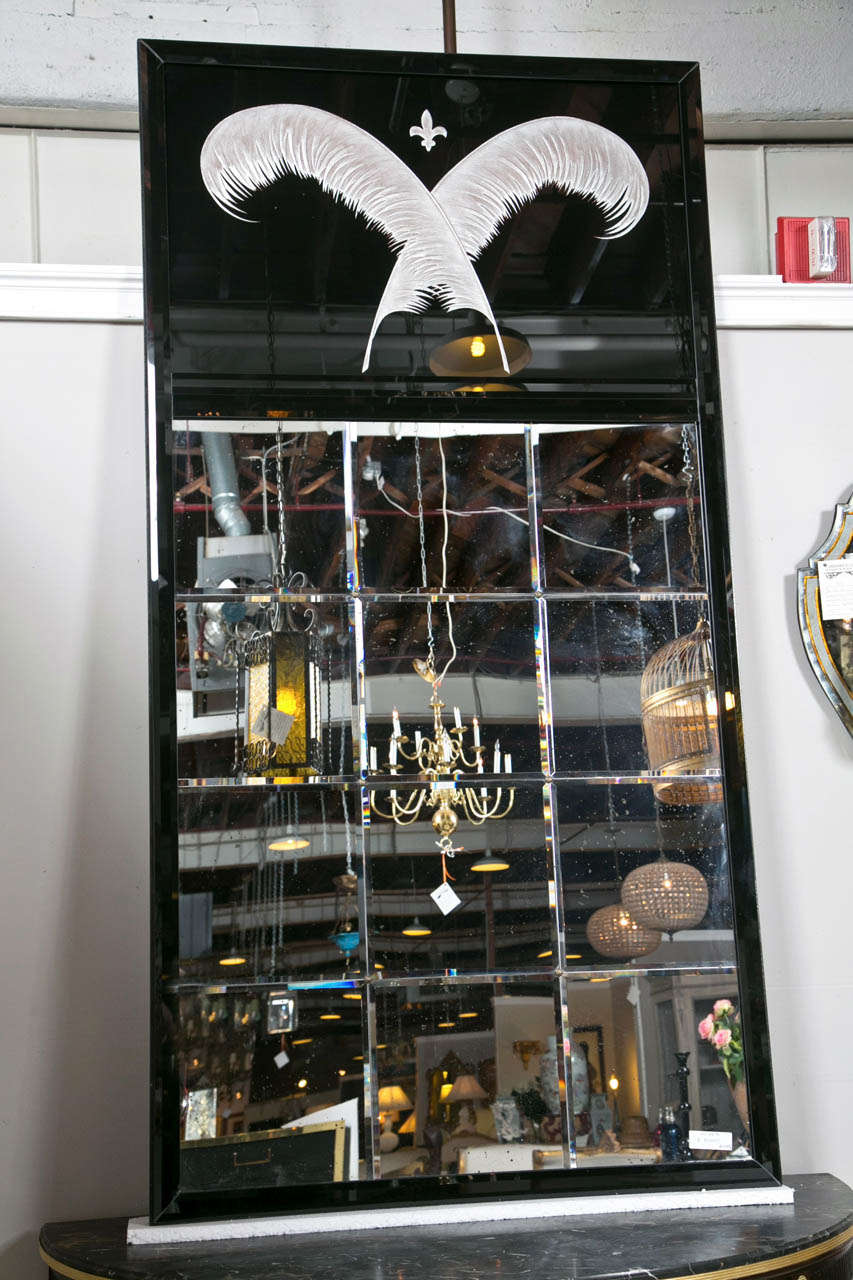 Pair of Art Deco style mirrors, monumental in size, in a black tinted glass frame, the top depicting a reverse painted plume motif, the bottom having a group of twelve beveled paneled mirrored glasses. The over all structure supported by a steel