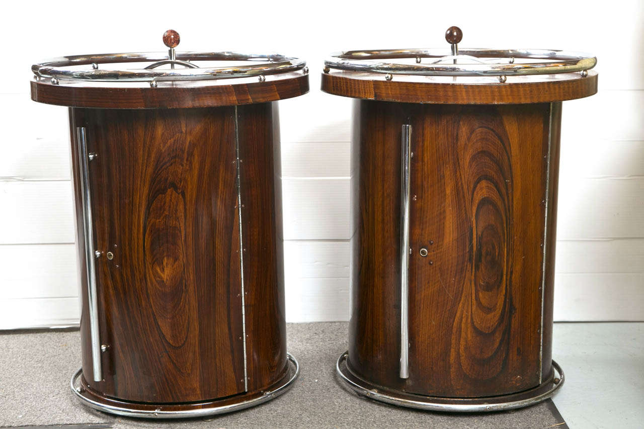 Pair of intriguing rosewood bar tables (end tables) in the Art Deco taste, each having a chrome gallery and accents, the tubular cabinet opening to custom-fitting interior used to store and hold pipes, raised on chrome base. The top with an pull up