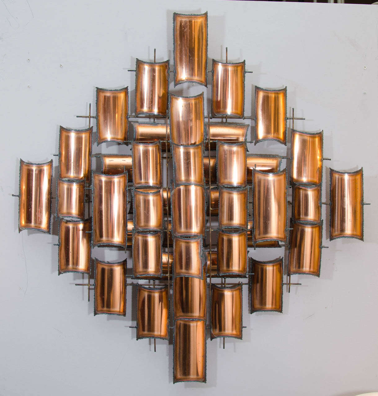 Striking wall sculpture with torch cut copper elements arranged in a grid. Very nicely done. May be mounted vertically as shown or horizontally or diagonally. Please contact for location. 