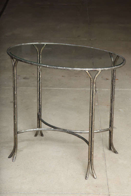 A lovely faux bois silvered iron oval table side table with a glass top, France, circa 1960s.