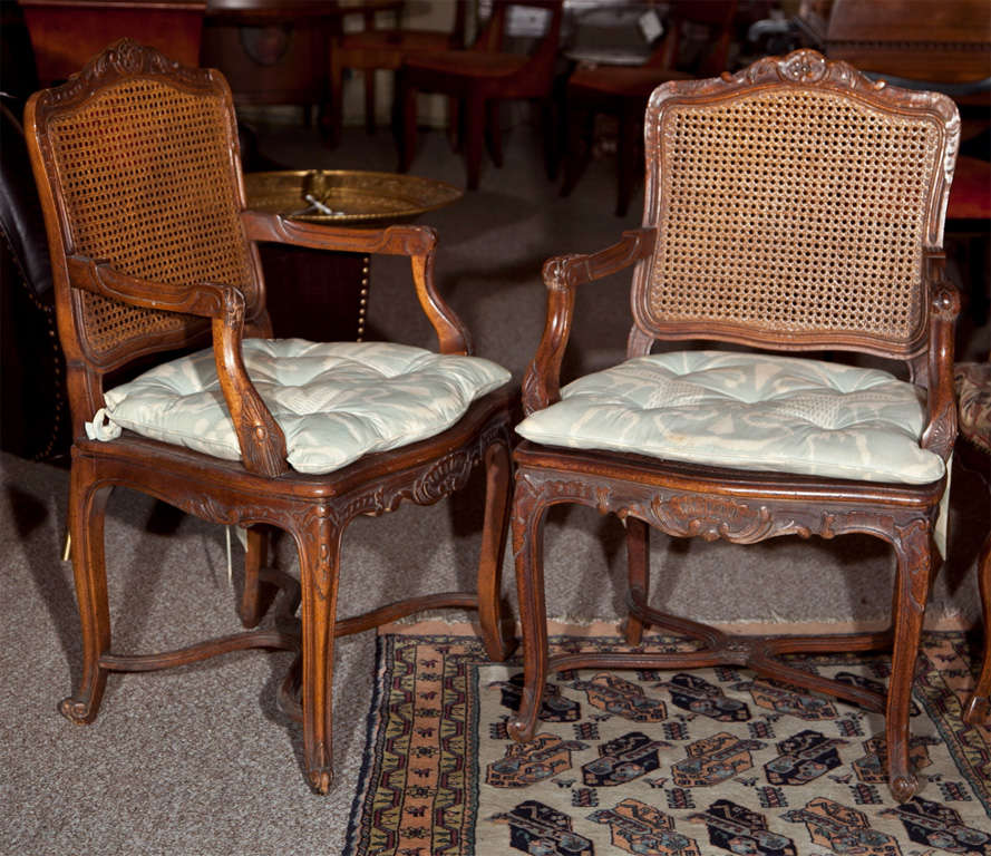Pair of French Provincial caned armchairs, 20th century, in the style of French Louis XV, caned back and cushioned caned seat. Price is for each chair.