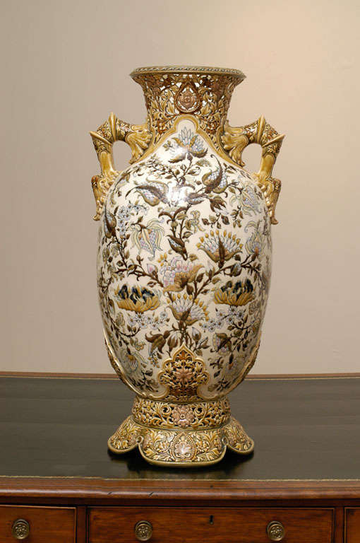 A fine and rare monumental Zsolnay porcelain vase, circa 1880. The vase has a flared neck with an openwork floral field. The main body just below with a cream colored ground is painted with floral blossoms and vines. The large body is supported on a