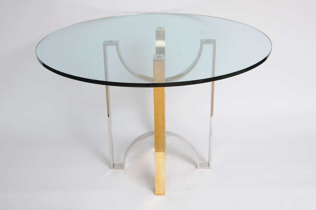 This is a well-crafted and designed solid brass and polish steel ribbon table base with round glass top.

(Keywords: Rizzo, Evans, Marx, Vautrin, Maison Charles, Ponti, Delon, Jansen).