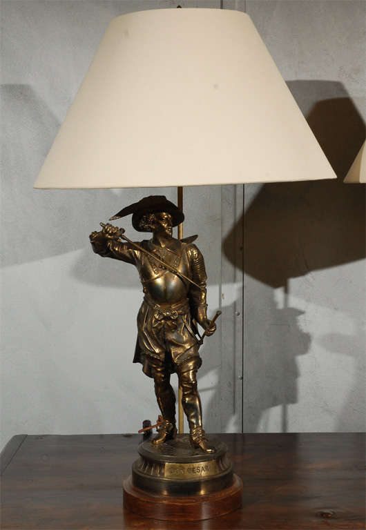 A pair of patinated bronze Cavalier figures mounted on turned wood bases as table lamps. The figures are thought to be late 19th century, made into lamps in the 20th century.