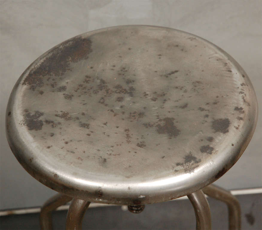 This polished metal  medical stool has a revolving seat. The height goes from 24