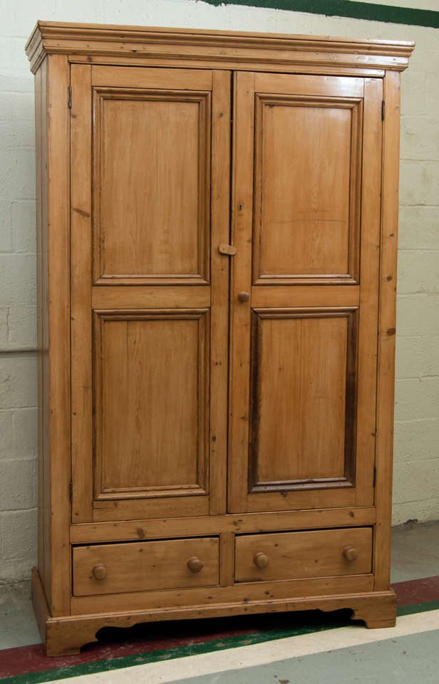 A large pine armoire featuring two panelled doors above two lap-jointed drawers.  A rare opportunity to acquire a genuine Irish armoire at a reasonable price.