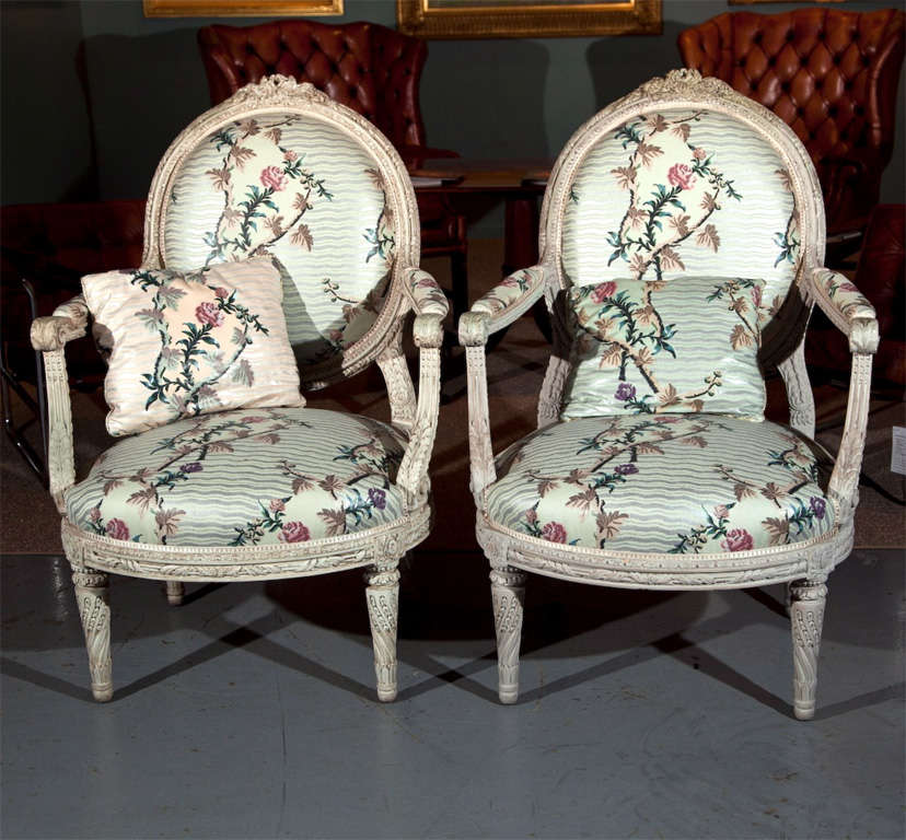 Fabulous pair of Louis XVI style carved open arm bergeres. Beautifully painted frame and gorgeous fabric.