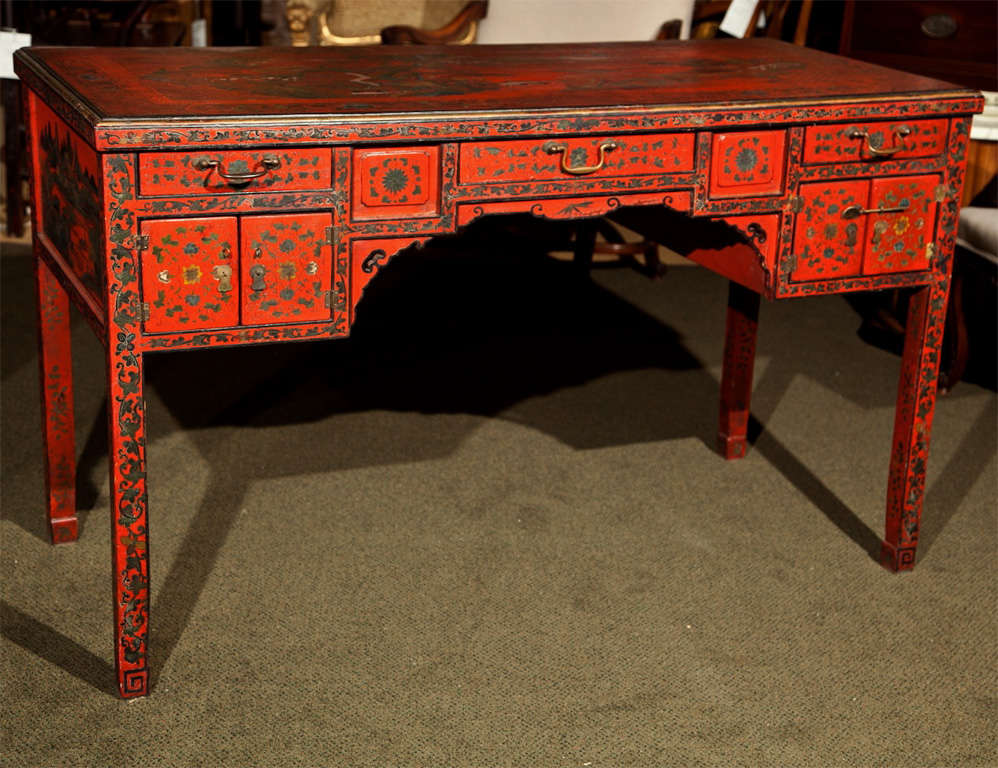 A red lacquer desk with chinoiserie decoration.