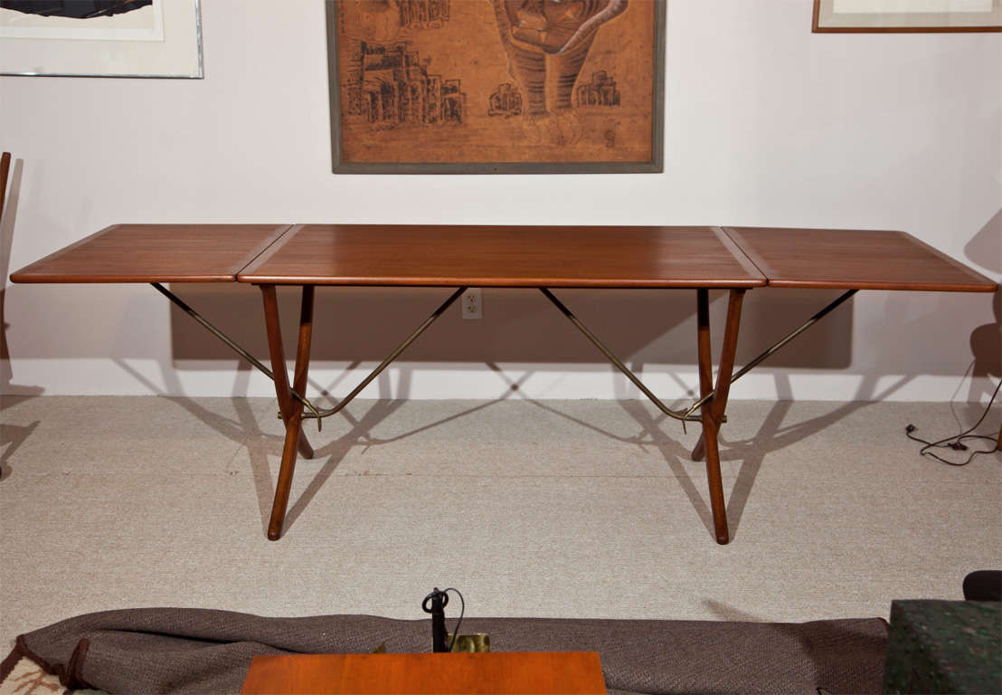 A teak dining table designed by Hans Wegner in Denmark with clean design lines. The leaves are lifted to increase the length of the table. Model AT-304 produced by cabinet makers Andreas Tuck.