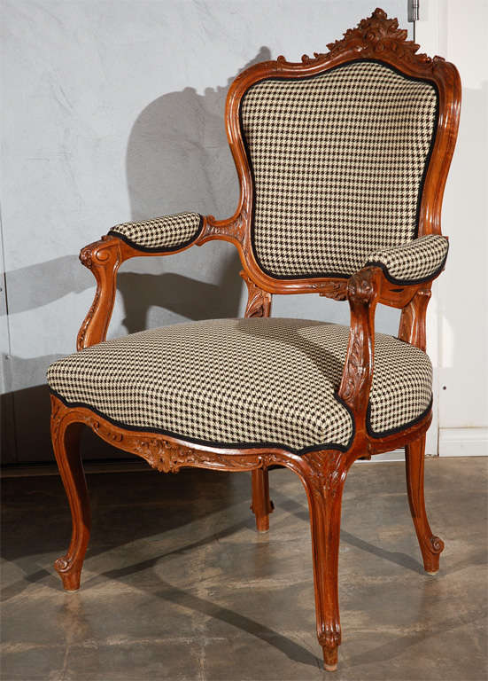 These open arm chairs are in carved walnut with houndstooth and gaberdine upholstery. They have detailed carvings and cabriole legs. A matching canape is also available. 