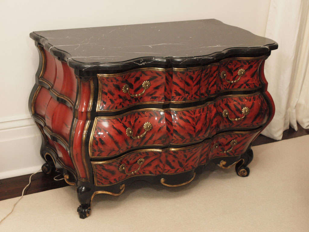 Impressively lacquered four-drawer bombe chest with conforming black marble plateau and satin brass pulls; manufactured by Quatrain to custom finish specifications