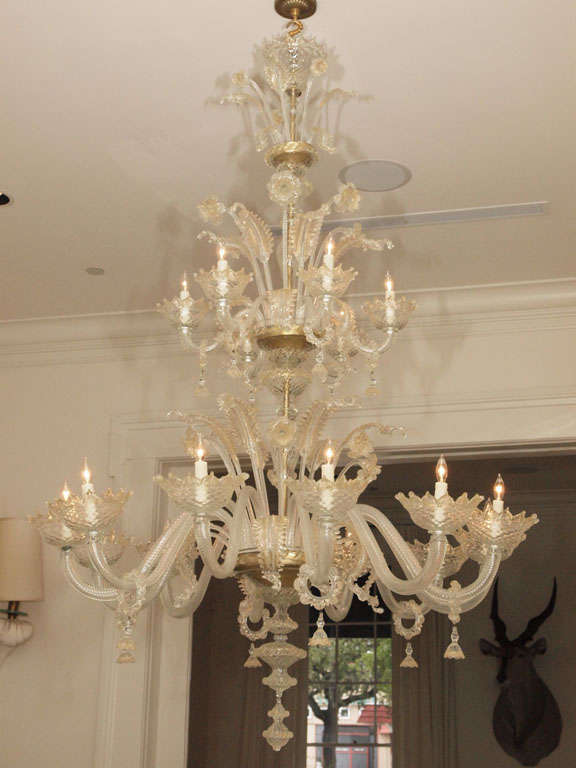 Exceptionally large mouth-blown Murano chandelier in clear glass with gold inclusions; the upper tier with six lights below a spray of leaves and flowers; similar detailing at the lower, twelve-light tier; extravagantly detailed throughout