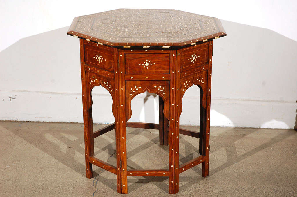 Fine and elegant Anglo-Indian octagonal rosewood table with elaborate ivory and ebony inlay.The octagonal surface is finely carved and inlaid with ivory and ebony designs of a  large star and vines. The base fold flat.

Mosaik provides
