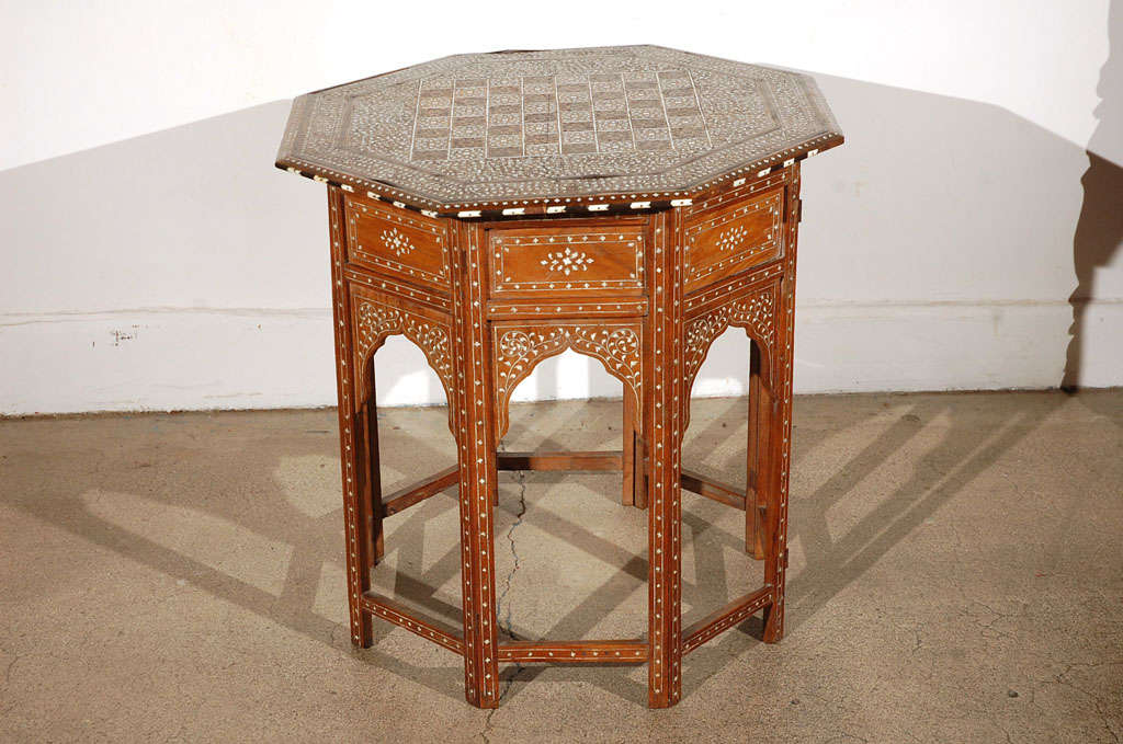 Fine and elegant Anglo-Indian octagonal rosewood table with elaborate ivory and ebony inlay.The octagonal surface has an inlayed chess board design.<br />
The base fold flat.