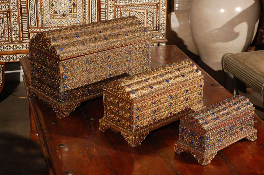 Set of three Asian gilt wooden boxes nicely carved and encrusted with semi-precious stones, glass, mirrors and brass.
Handcrafted in Thailand.
The small one is 13