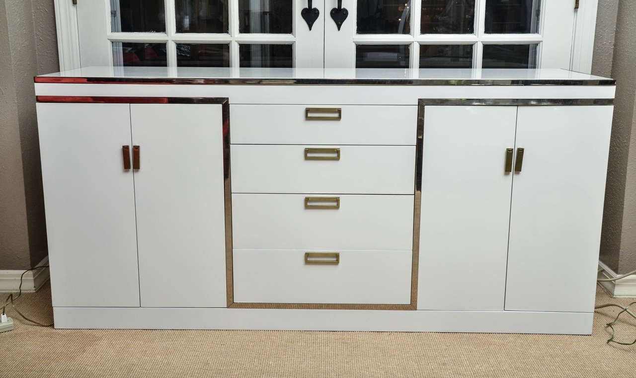 Attractive white lacquer buffet with four central drawers and two cabinets. The drawer pulls are gilt metal.