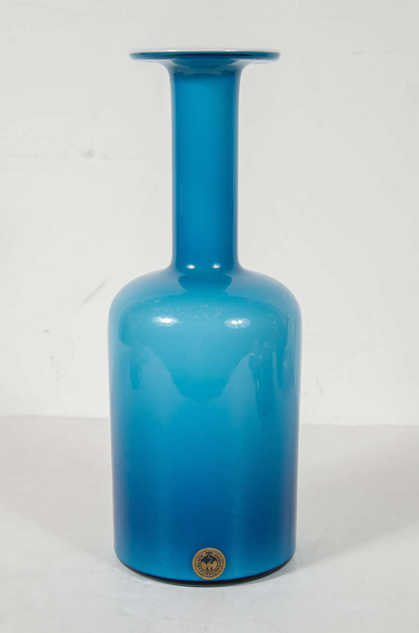 Mid-Century Modernist Turquoise Glass Vase by Otto Brauer for Holmegaard.  This hand-blown glass vase is in a stunning turquoise color that has a slight ombre effect to it given its curves from the overall design.  The interior color is in a