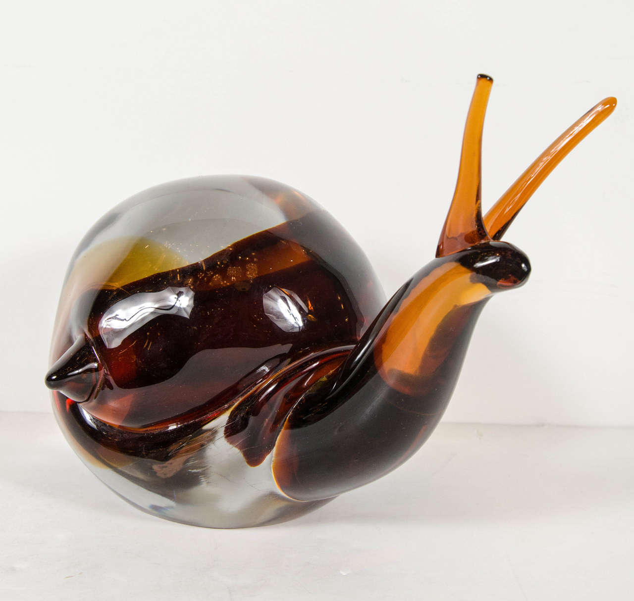 Mid-Century Modernist hand-blown Murano glass snail by Alfredo Barbini.  This exquisite, hand-blown Murano glass sculpture is done by Alfredo Barbini and features a large glass snail in a deep, rich Amber hue that is incased within its hand-blown