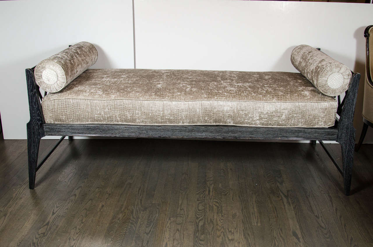 This ultra-chic Mid-Century Modernist silver cerused daybed in the manner of Andre Arbus features a strong design with its streamlined finish and stylized detailing. The extra plush cushion has been newly upholstered in a gauffraged crocodile velvet