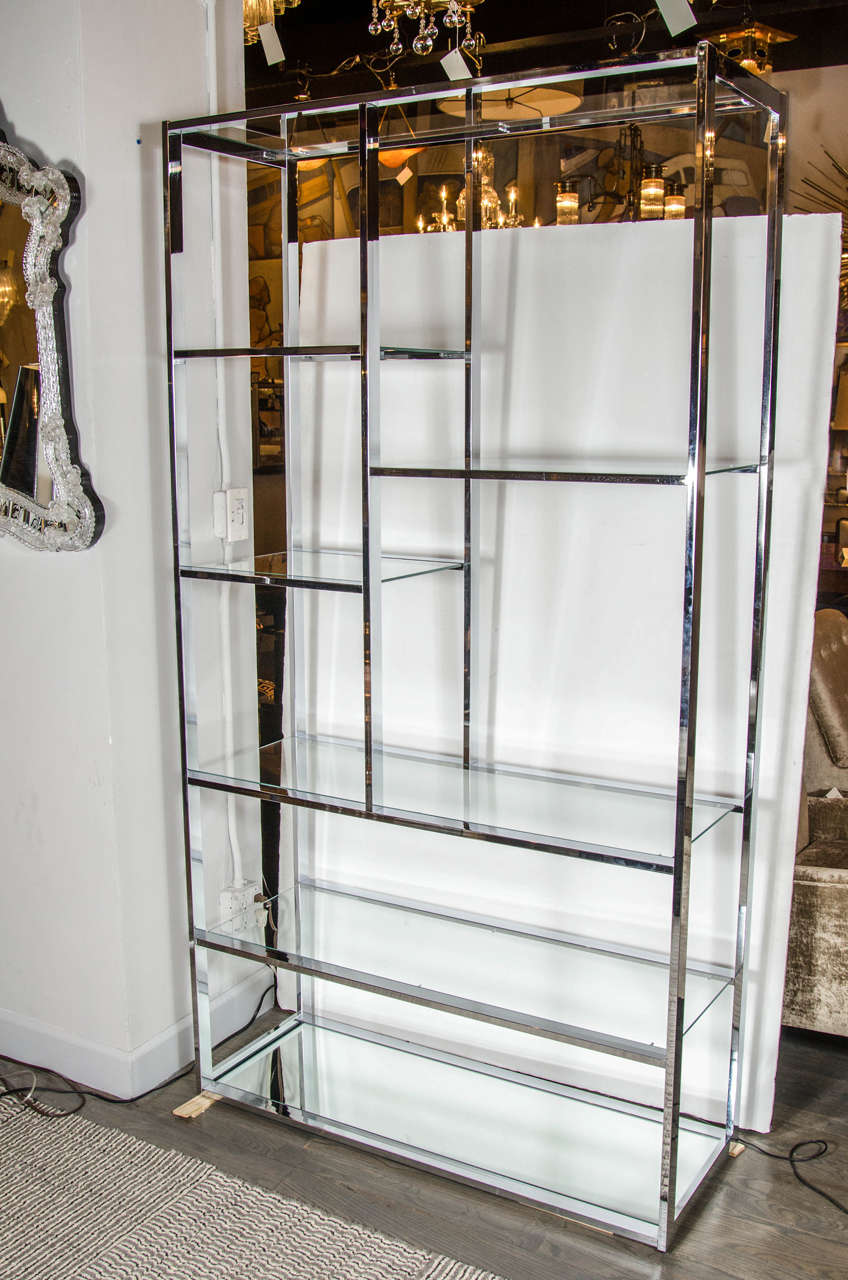 This outstanding etagere can be used to display decorative pieces or can make a great room divider. It has a chrome frame with glass shelves and mirrored bottom shelf. It is designed by Milo Baughman and is in mint condition.