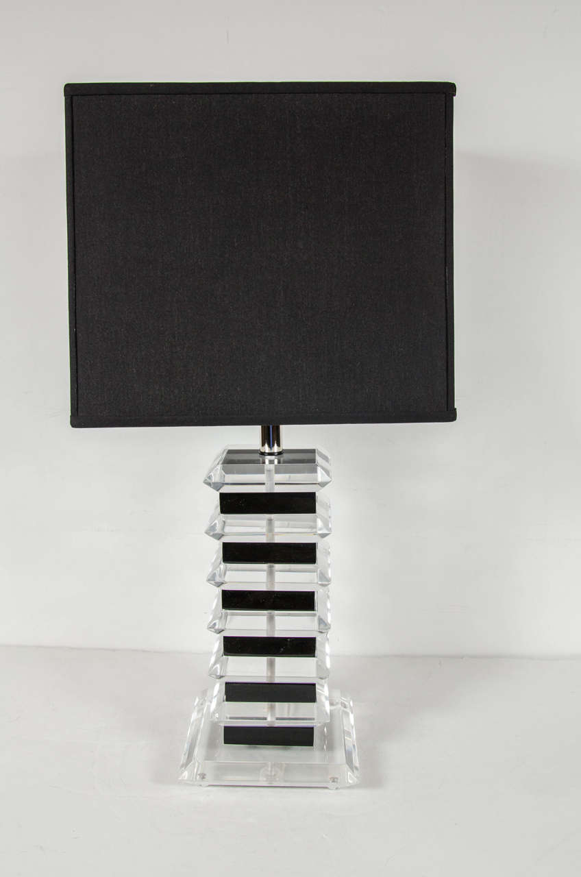 This pair of chic Mid-Century Modernist table lamps feature contrasting black and clear Lucite squares forming the stem of the lamps, the base is clear Lucite and the fittings are chrome. Newly rewired and includes new custom shades.