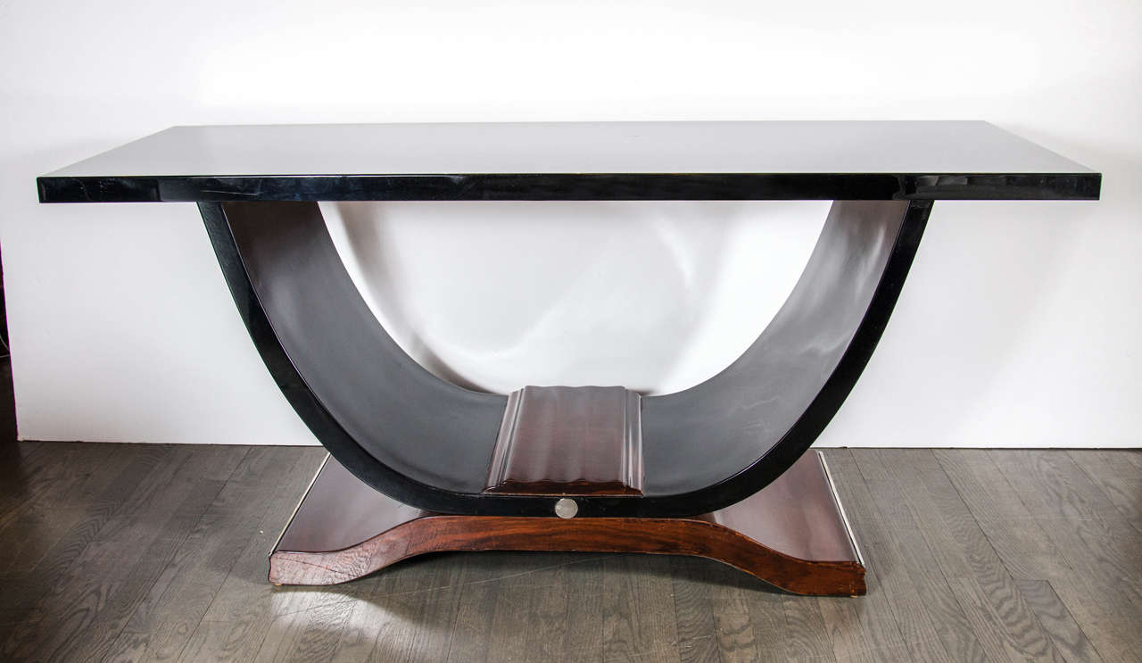 Elegant Art Deco console table in the manner of Ruhlmann with black lacquer top and arched base that sits atop an exquisite rosewood scrolled pedestal. The black lacquer arched base is topped with a centerpiece of rosewood giving it a floating