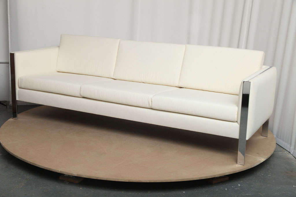 Simple yet really elegant design, the metal structure going though each armrest shows only its narrow side, giving the sofa an illusion of lightness. In the style of Milo Baughman or even Stendig-Massimo-Vignelli.