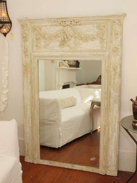 Breathtaking painted antique trumeau mirror with layers of white paint, carved floral and ribbon details.
