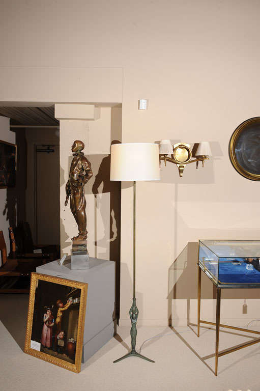 A neoclassical patinated bronze floorlamp, the base depicting an Egyptian woman holding a jar, Italy, circa 1950.

(With Modern Lampshade).